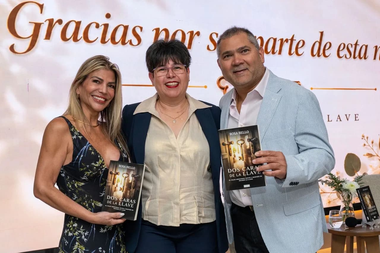 Invitados sostienen el libro Dos Caras de la Llave durante el lanzamiento