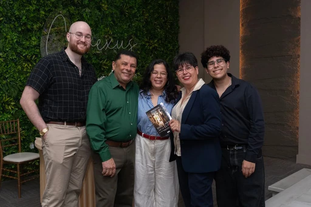 Familia de asistentes con el libro Dos Caras de la Llave en el lanzamiento