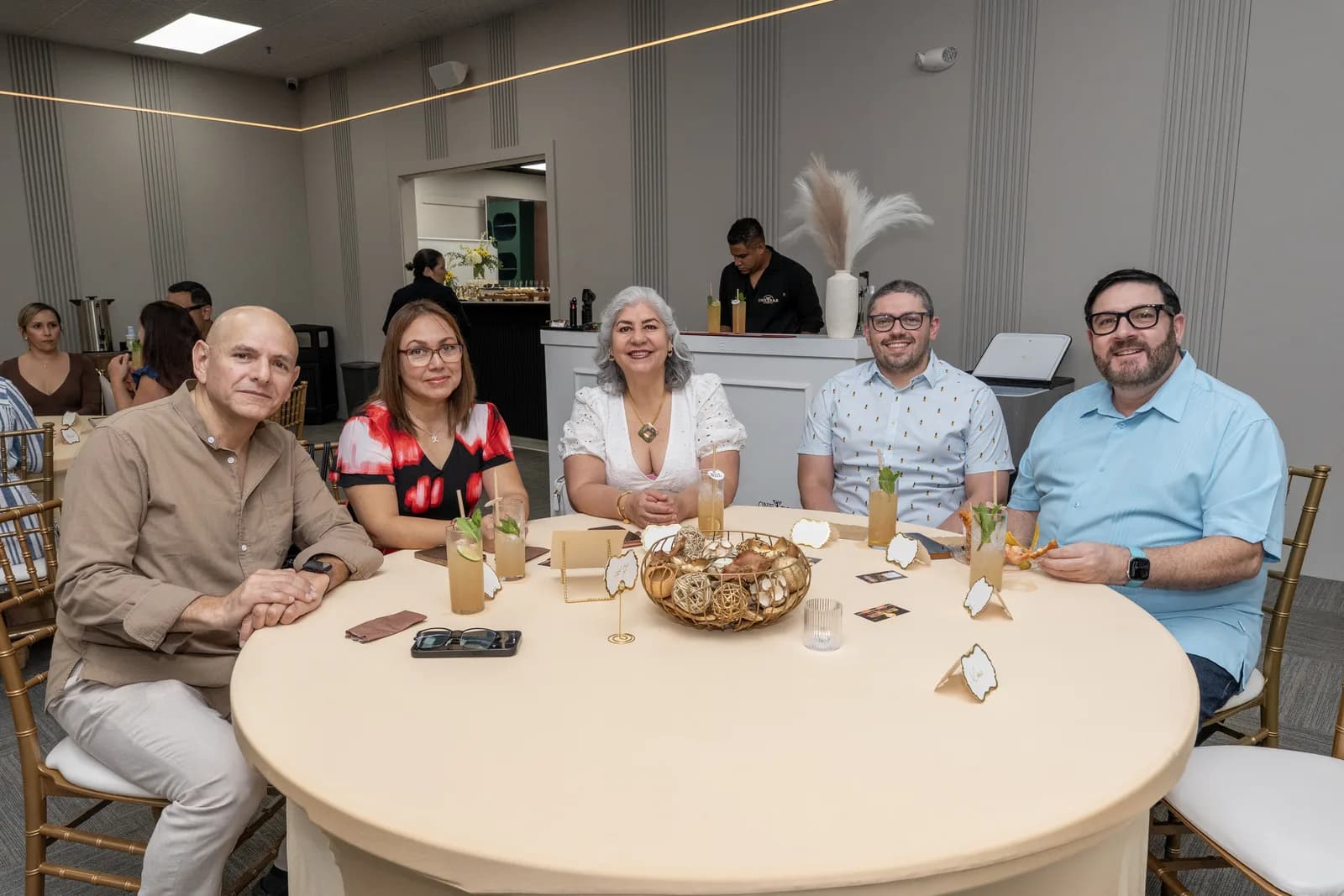 Invitados conversan en una mesa durante el lanzamiento